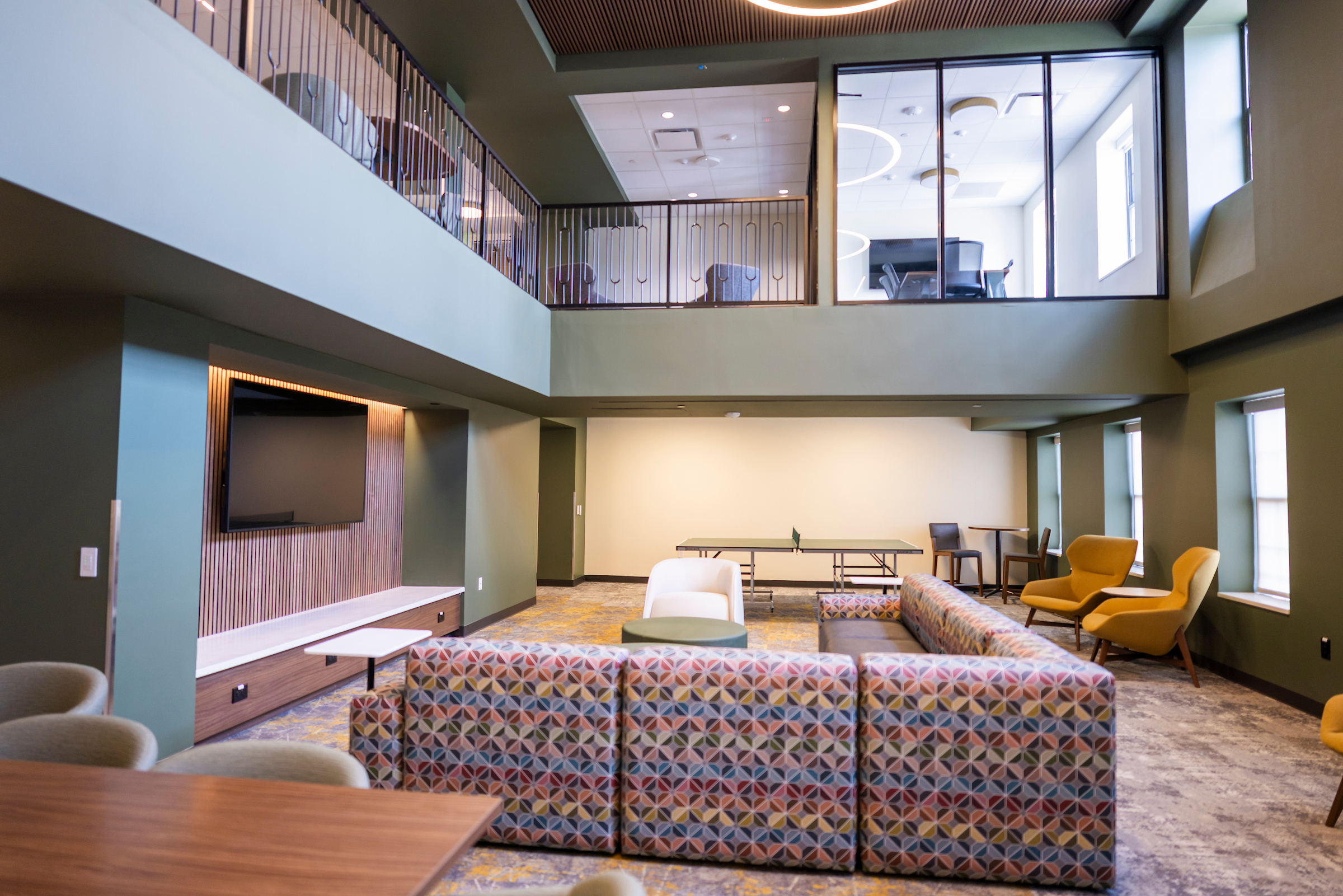 Communal Commons 2nd Floor including the ping-pong table, seating, the TV, and a view of the Commons 3rd Floor above (including the study room).