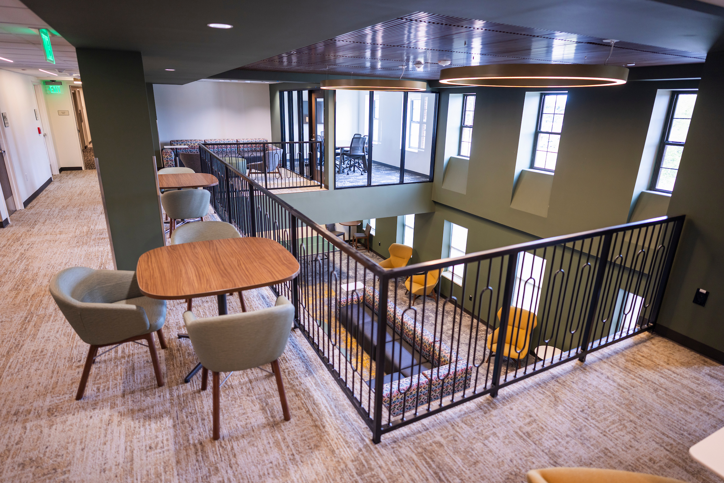 View from the 3rd Floor of the commons. Looking at tables, seating, windows, and the overlook.