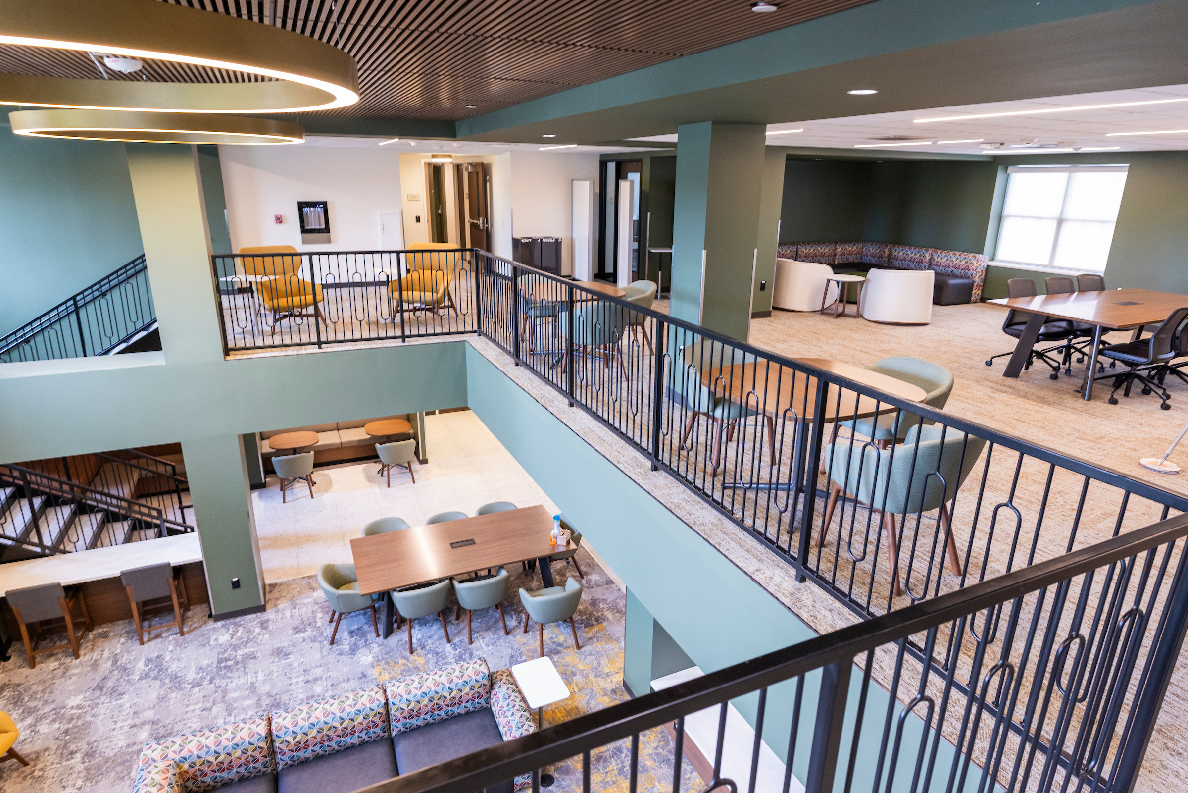 A different angle of the Commons 3rd Floor that includes more seating, white boards, tables, and a different view of the Commons 2nd Floor