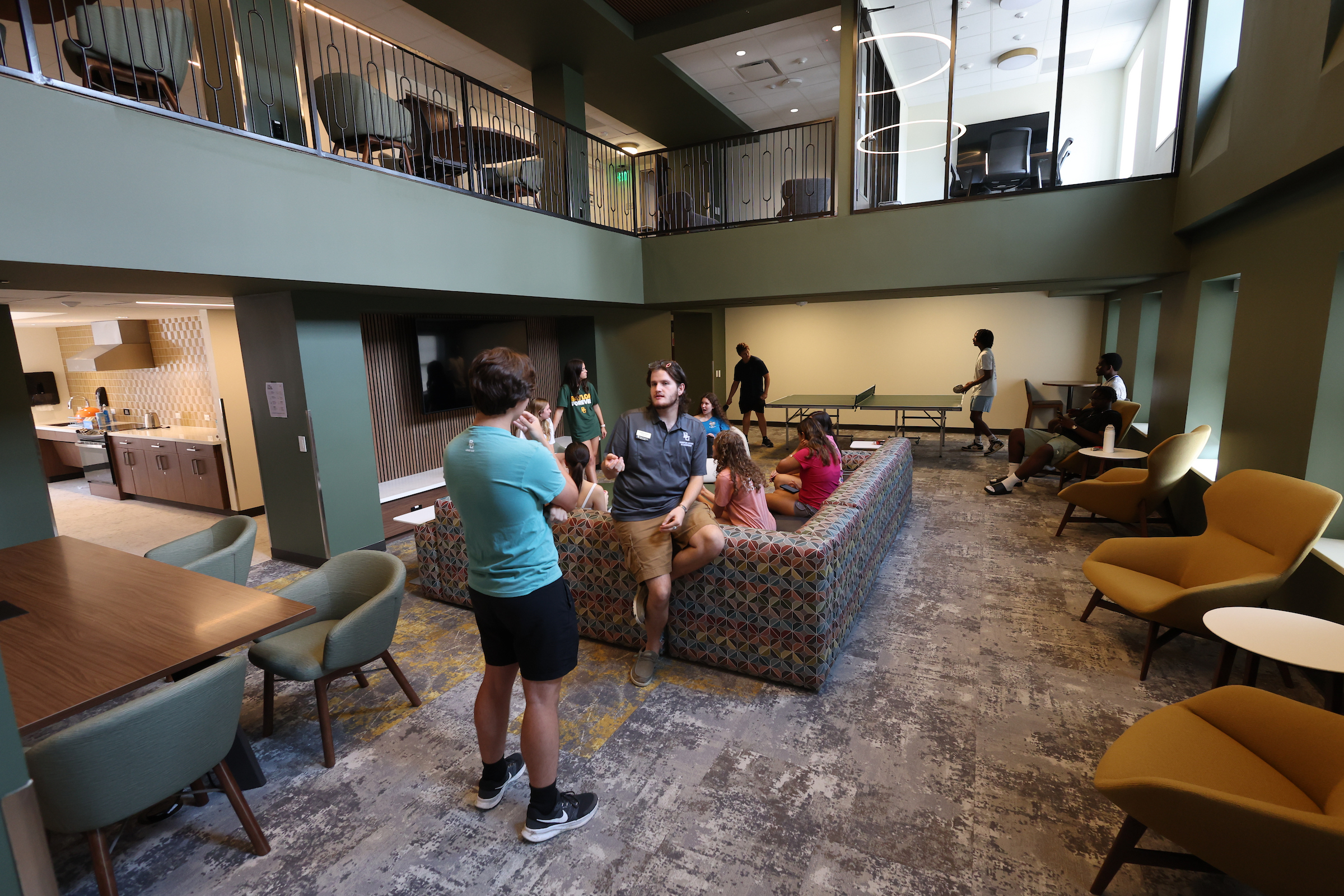 View of students enjoying the Commons 2nd Floor, including a bigger view connecting the Community Kitchen into the space.