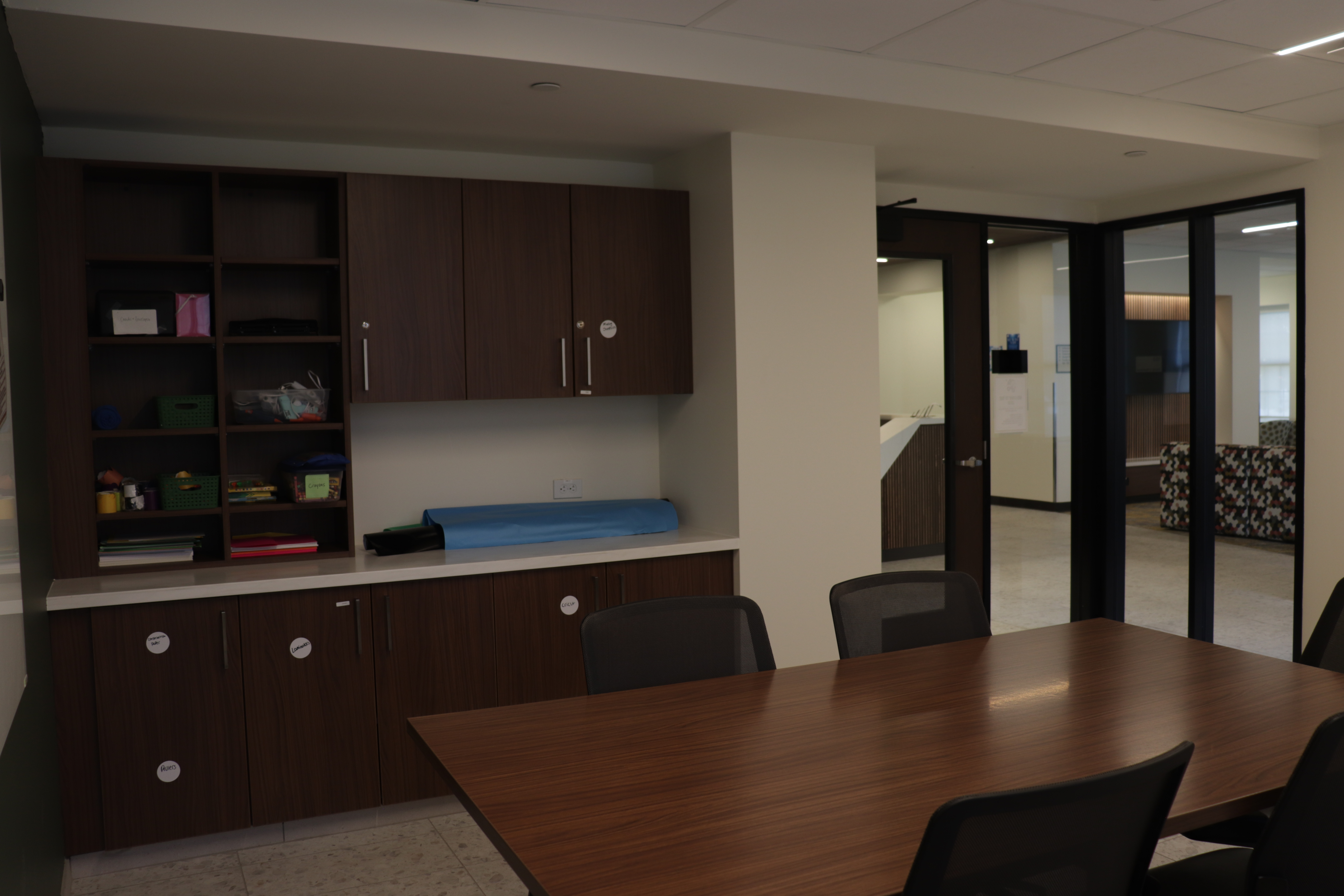 Study tables in the LRX and shelves full of supplies for students to use.