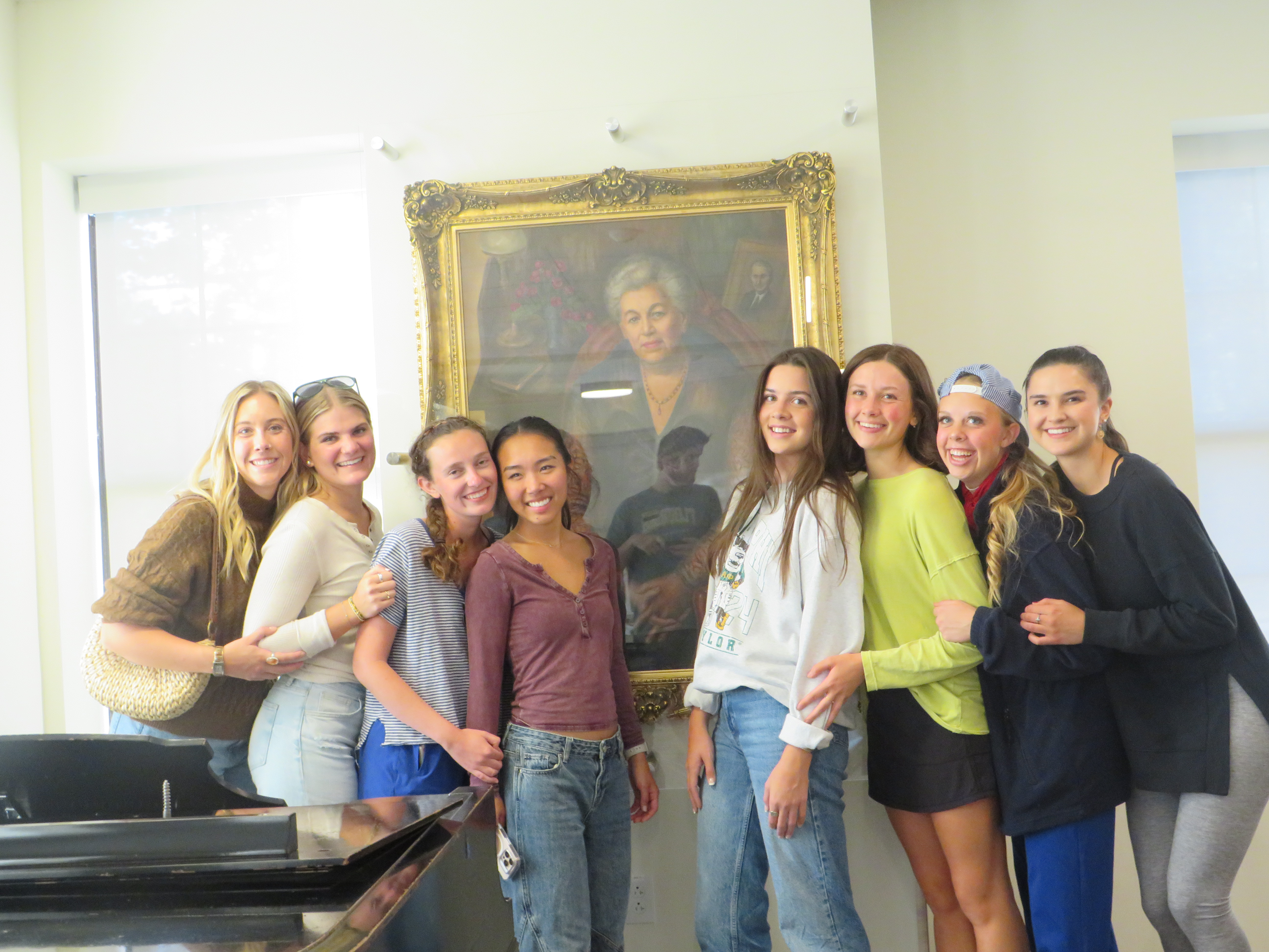 Alumnae of LEAD LLC posing in front of Willie Dawson's portrait. 