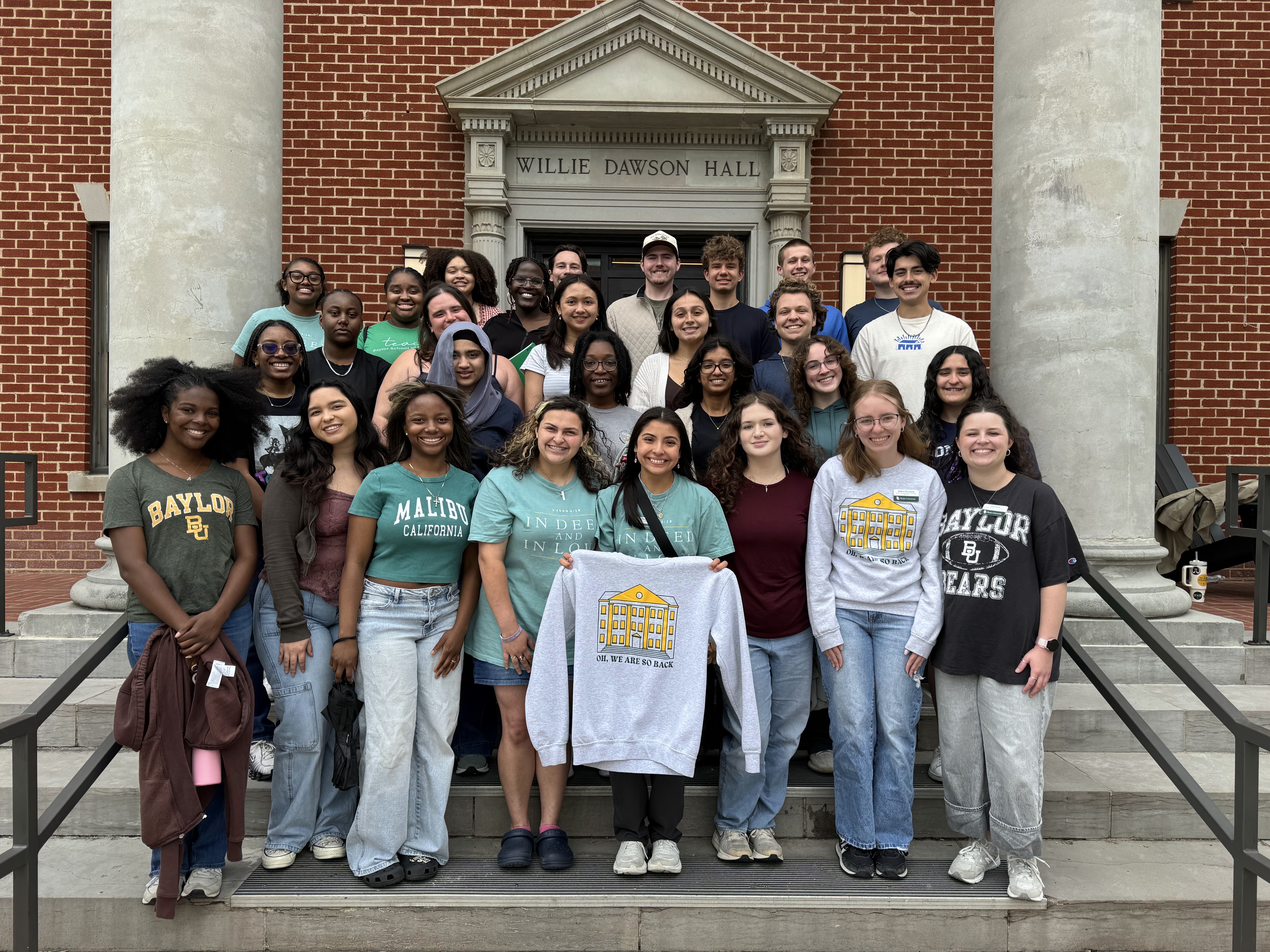 A group of students, known as LEAD Team, on the steps of Dawson Residence Hall. 